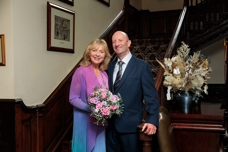 wedding couple on grand staircase at Audleys Wood