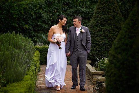 couple walking in the garden at manor gatehouse wedding