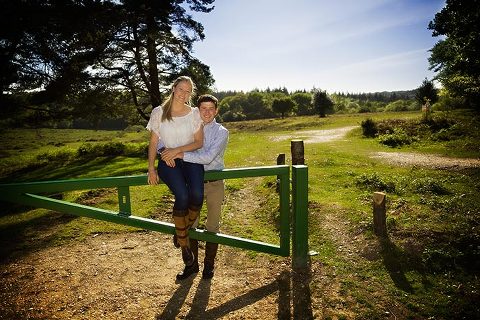 engagement photo sitting on a gate in the new forest