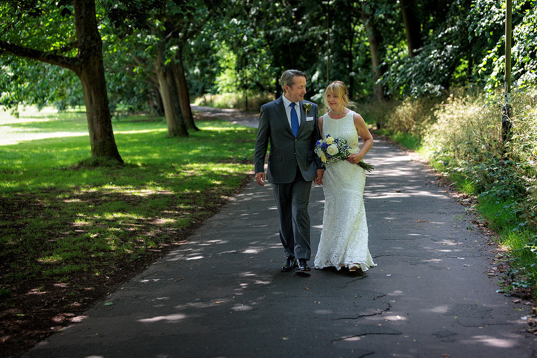 couple walking in war memorial park by Basingstoke wedding photographer
